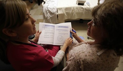 
              This photo taken Jan. 30, 2013 shows patient Marlena Bechtel-Rysdam, right, from Elgin, Ore., going over home monitoring training materials with registered nurse Christina Leese at Oreg